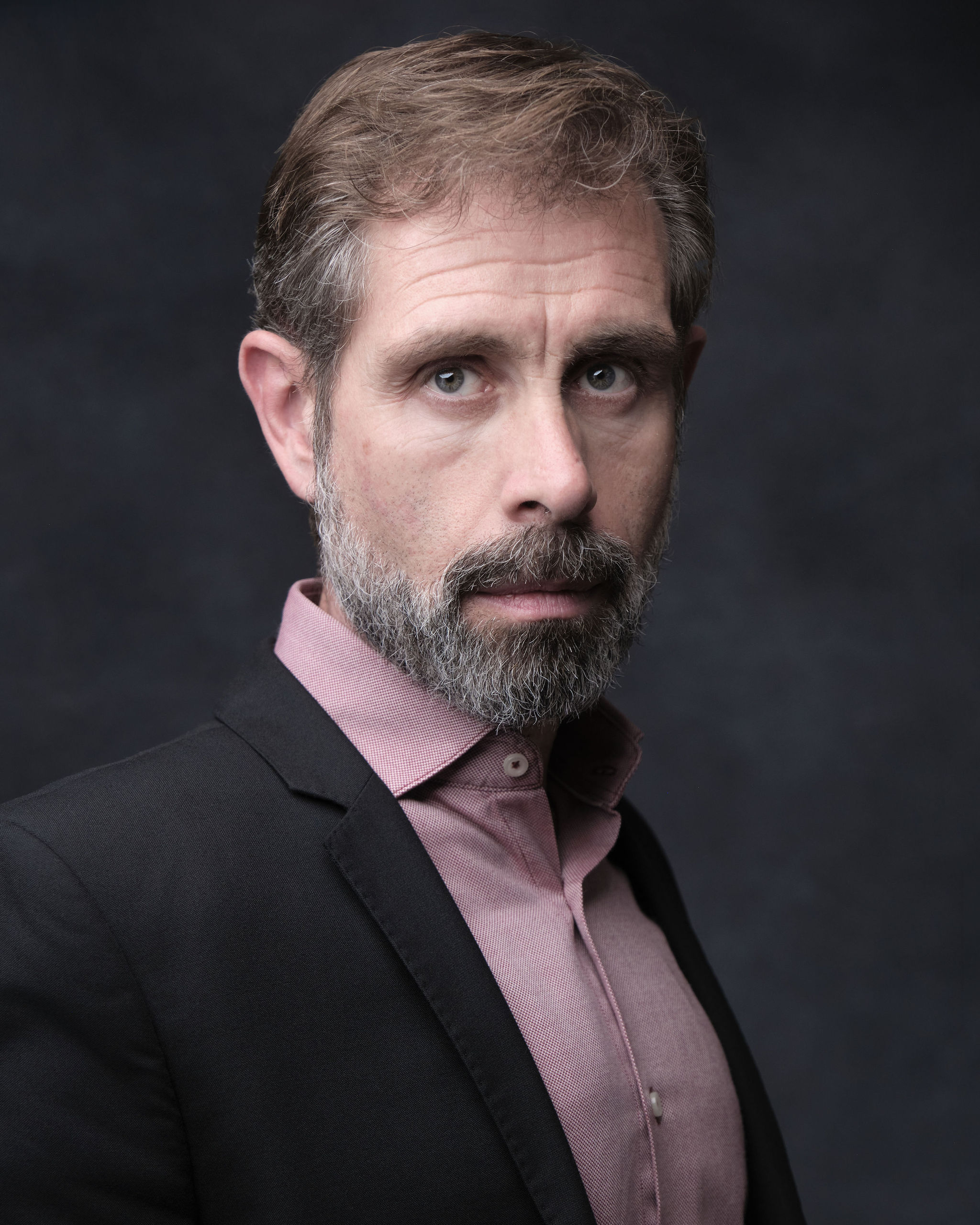 Iago Cabrero actor — Authority Figure, three-quarter portrait, pink shirt and dark jacket